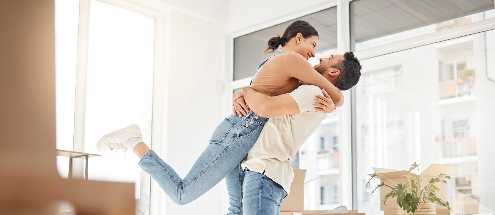 Paar umarmt sich nach Einzug in neue Wohnung