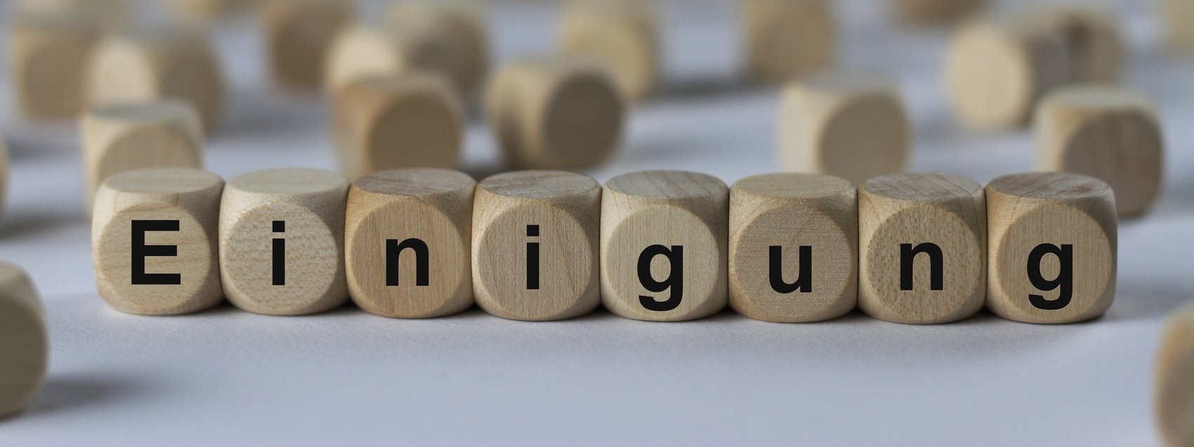 Einigung - Holzwürfel mit Buchstaben